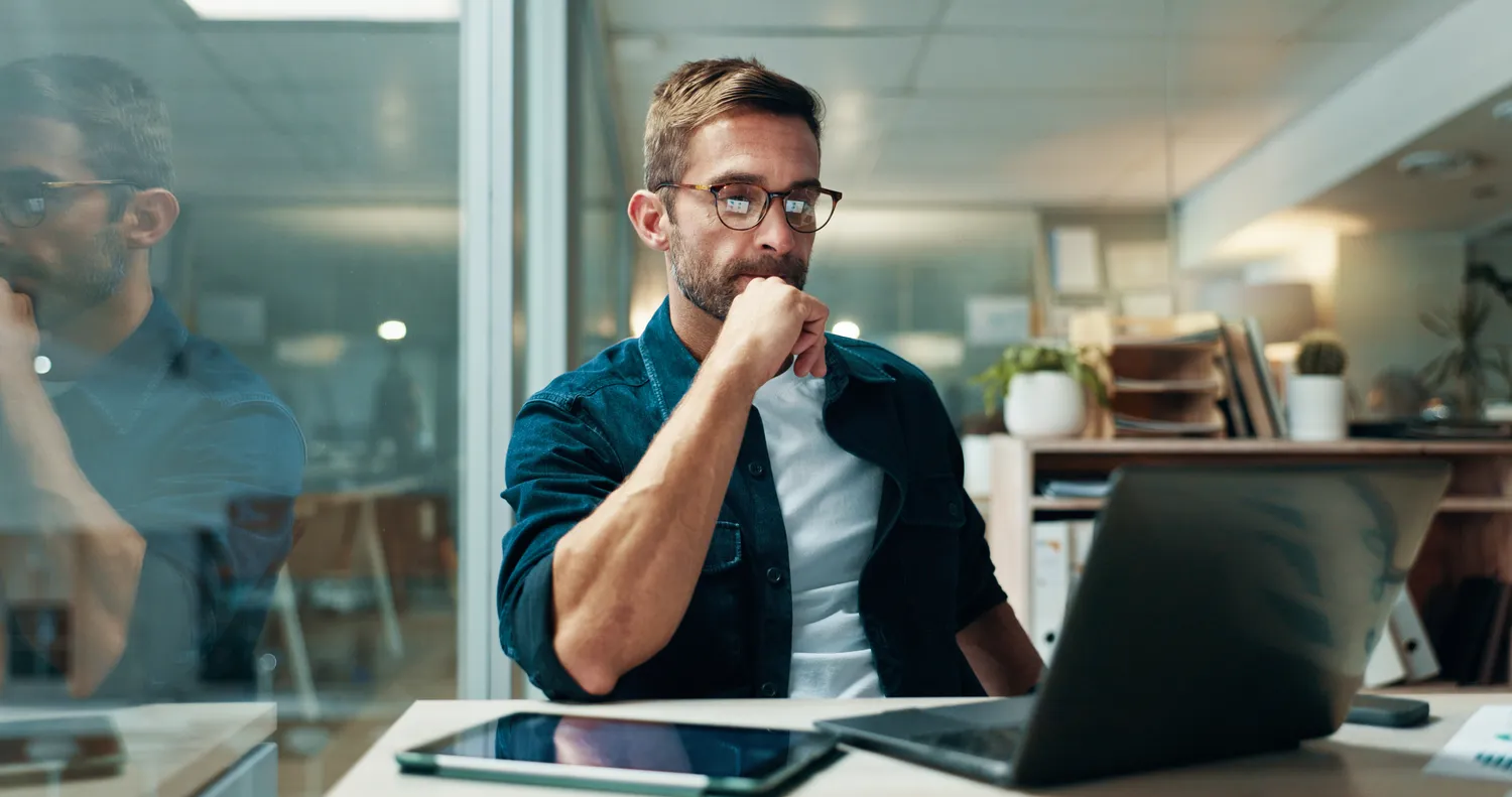 Pay Solution – Lohn- und Gehaltsberatung – Geschäftsmann, lesend im Büro mit Laptop, Bericht und souveräner Buchhaltungsexpertise. Pay Solution – Lohn- und Gehaltsberatung